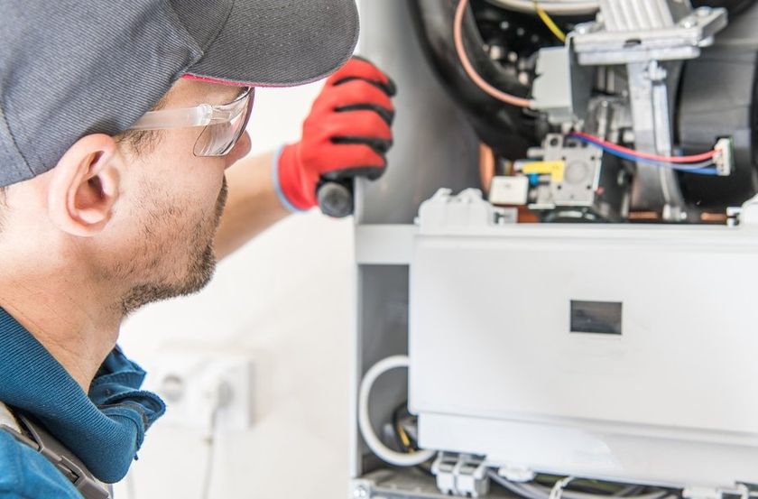 man in gloves repairing the boiler