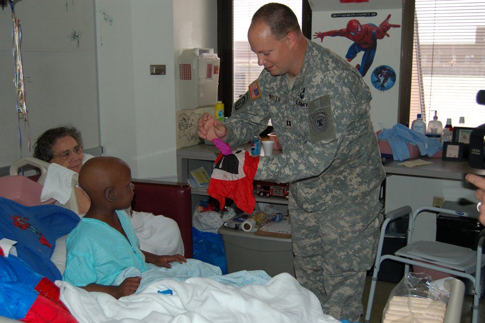 Corporate magic entertainer Matt Redlaw performing close-up magic for children in an Afghanistan hospital