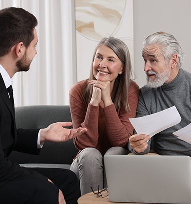 Financial advisor consulting with an older couple, reviewing documents.