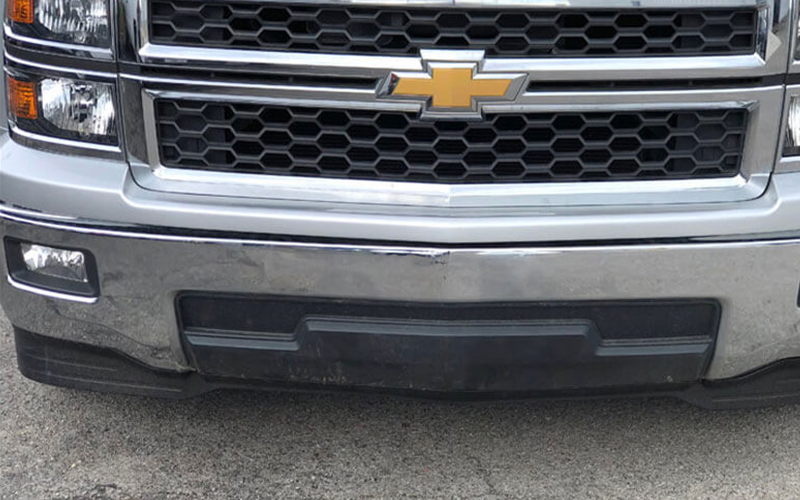 Silver Chevrolet truck front with black grill and bumper.