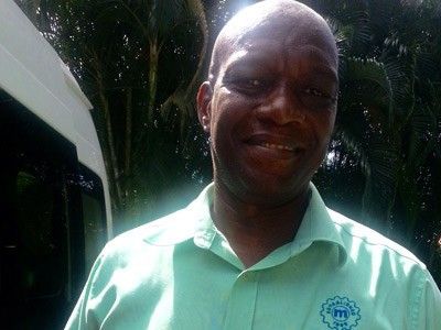 A man in a green shirt is smiling for the camera.