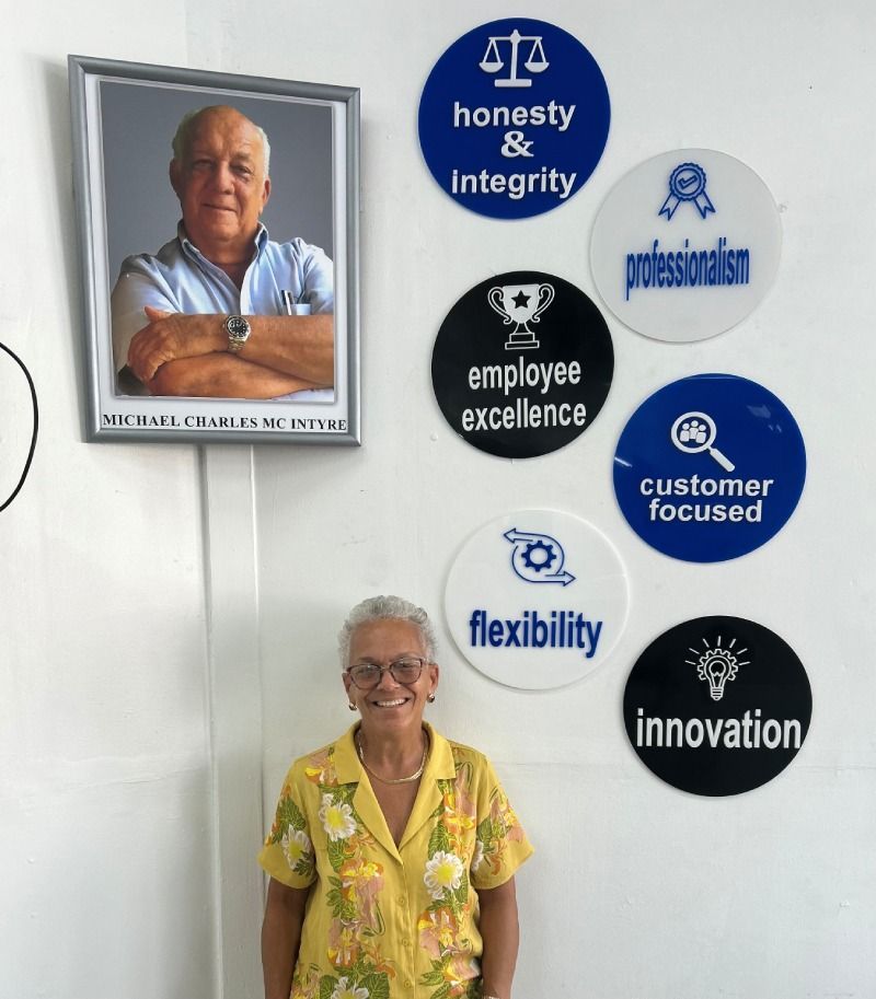 A woman is standing in front of a wall with a picture of a man on it