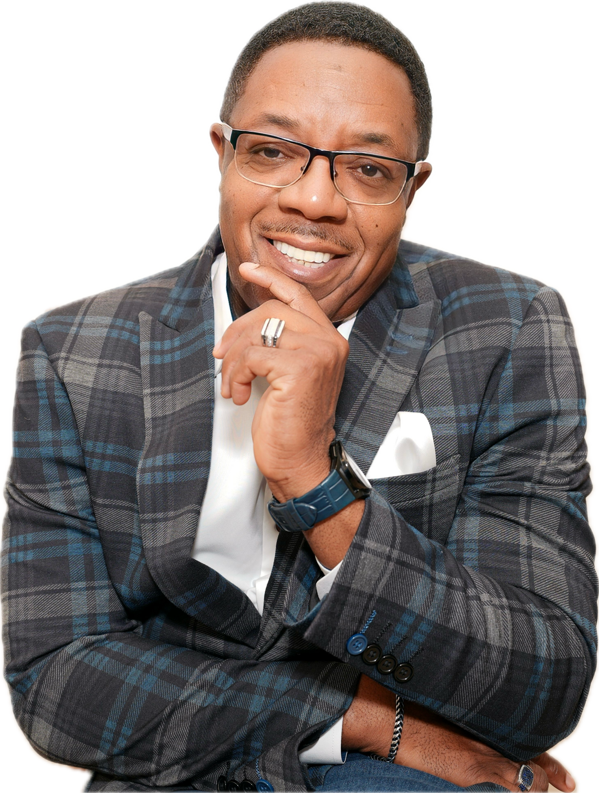 A man in a suit and glasses is smiling with his hand on his chin.