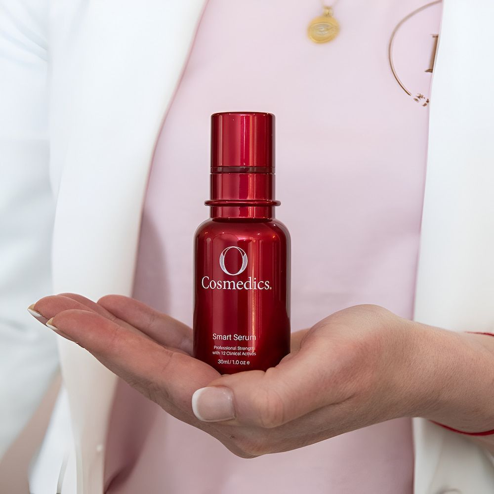 Person Holding a Red Cosmedics Serum Bottle — Eternal Radiance in Strathmore, VIC
