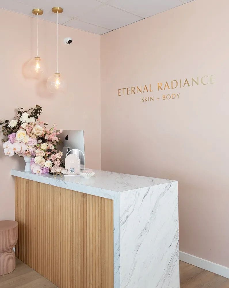 Reception Desk With Marble Top, Pink Walls, Gold Text — Eternal Radiance in Strathmore, VIC