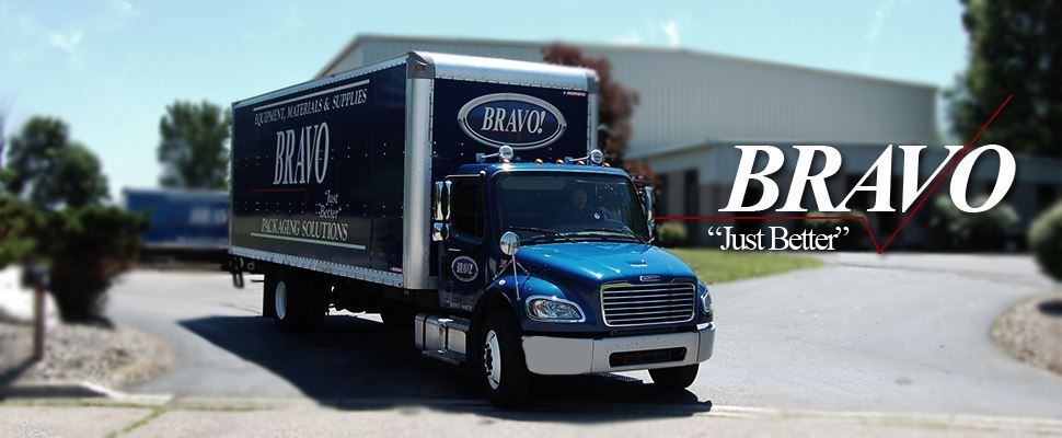 A blue and white truck is parked in front of a building.