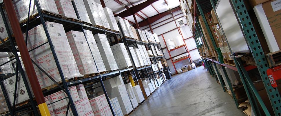 A large warehouse filled with lots of boxes on shelves.