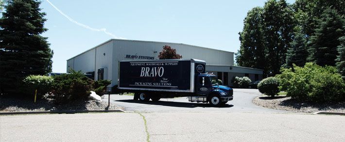 A blue and white truck is parked in front of a building.