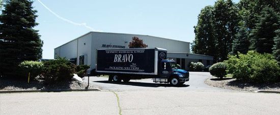 A blue and white truck is parked in front of a building.