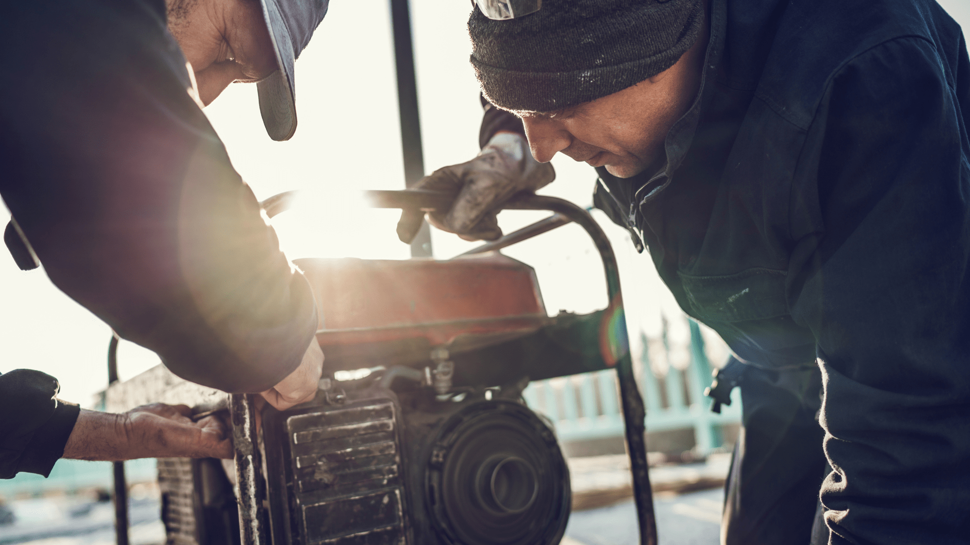 Two men are working on a generator together.