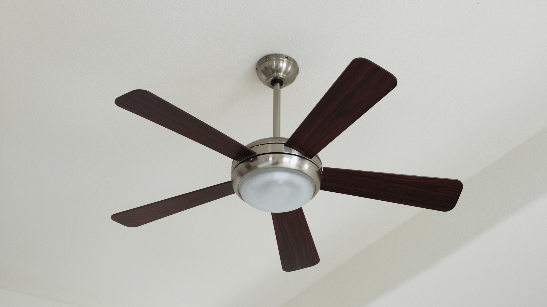 A ceiling fan with wooden blades and a light