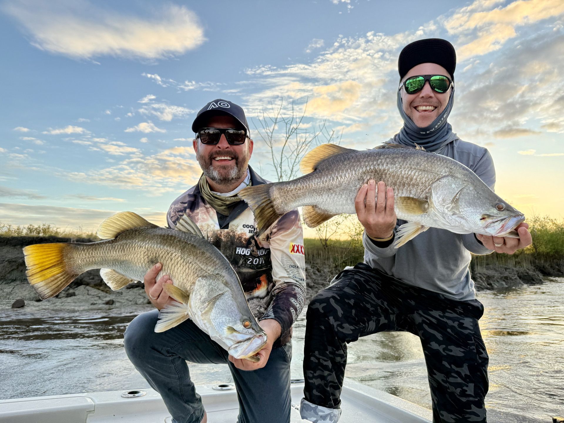 A Man In A Hat And Sunglasses Is Holding A Large Fish In His Hands — Territory Barra Sportfishing In Zuccoli, NT