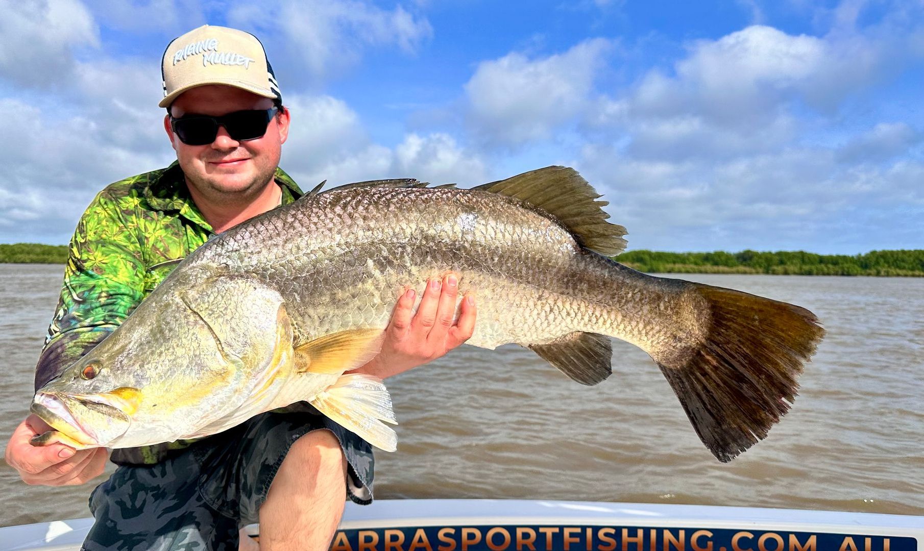 A Woman In A Hat Is Holding A Large Fish In Her Hands — Territory Barra Sportfishing In Zuccoli, NT