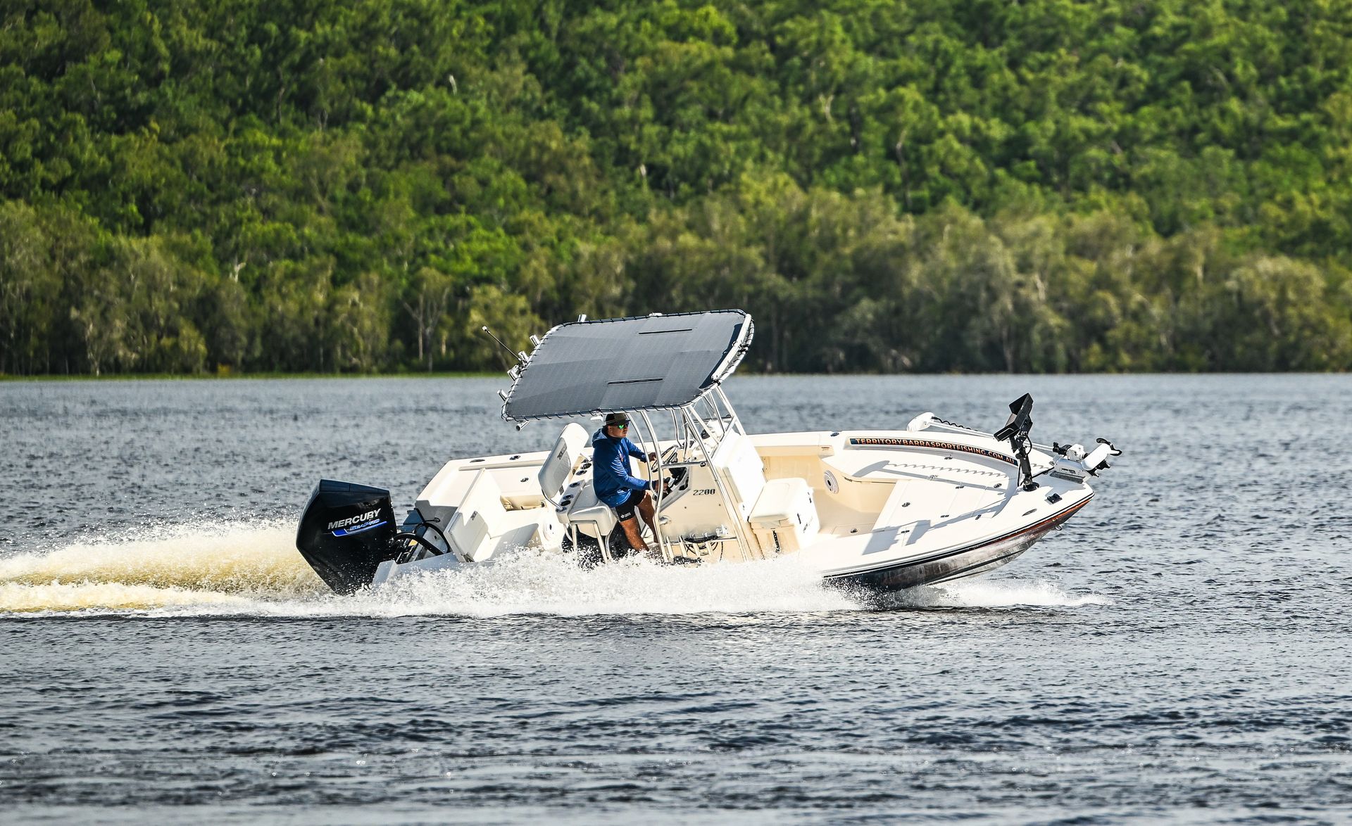 A Boat With A Mercury Outboard Motor Is Sitting In A Warehouse — Territory Barra Sportfishing In Zuccoli, NT