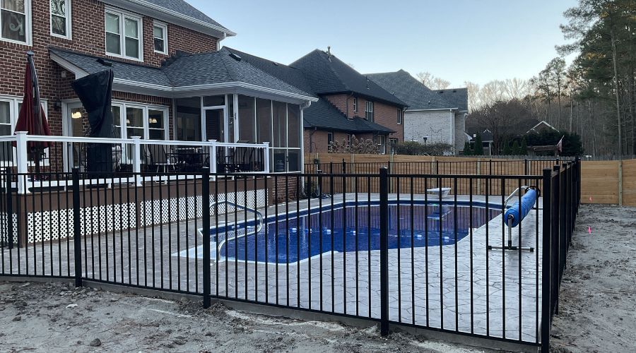 Black metal safety fence enclosing a residential swimming pool in St. Petersburg, FL