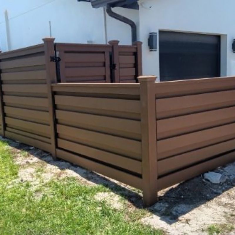A wooden fence is in front of a white house