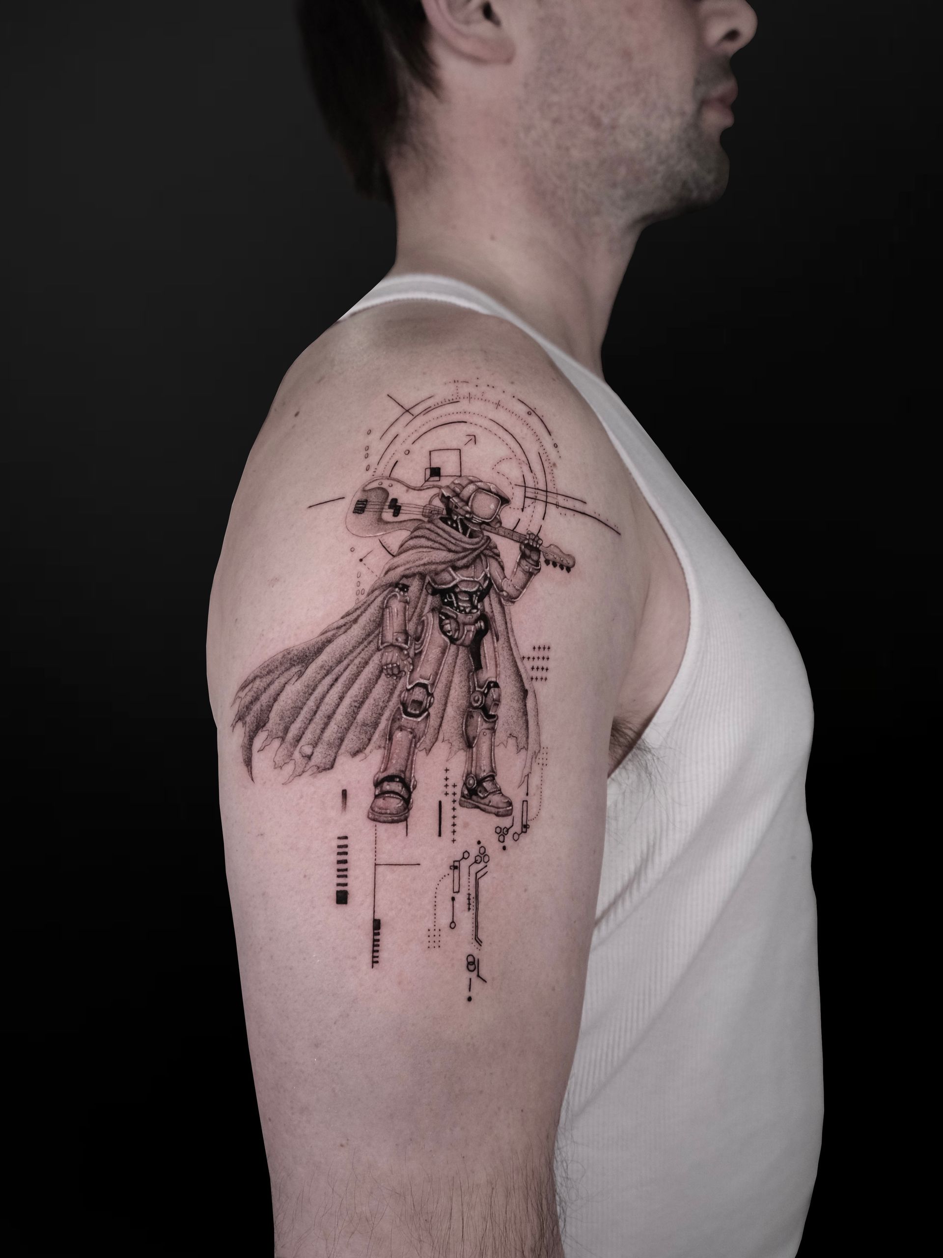 A detailed black-ink tattoo on an upper arm depicting a cloaked knight wielding a hammer in a sketch-like art style.