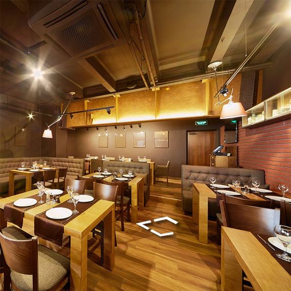 a restaurant filled with tables and chairs with plates and glasses on them