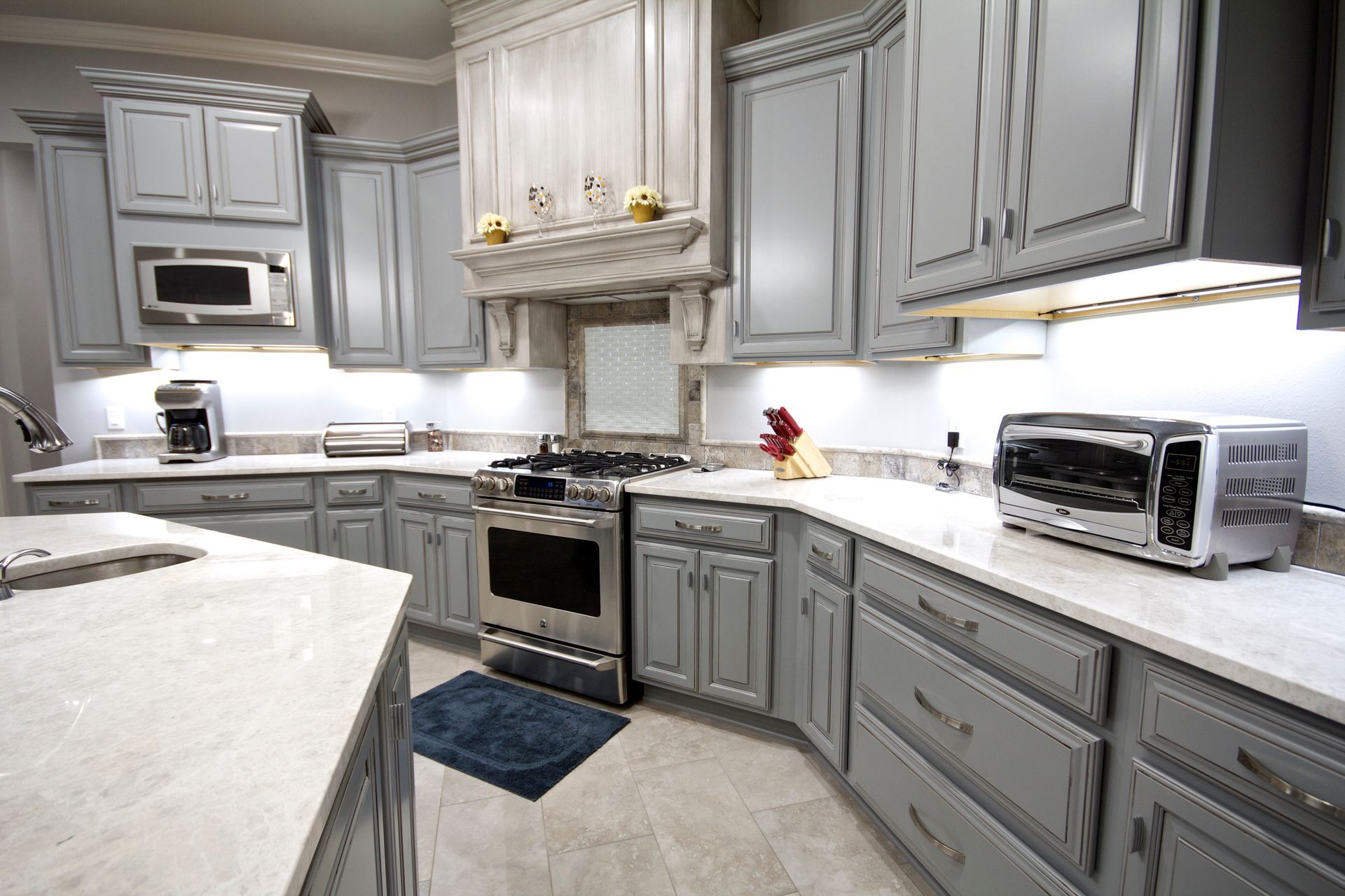 Renovated kitchen with gray cabinetry and under-cabinet LED lighting