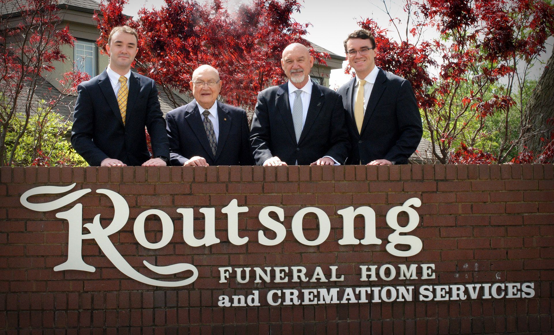 Routsong Staff in Front of the Funeral Home Sign