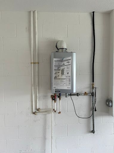 A water heater is hanging on a white brick wall.