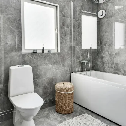 A bathroom with a toilet a bathtub and a window