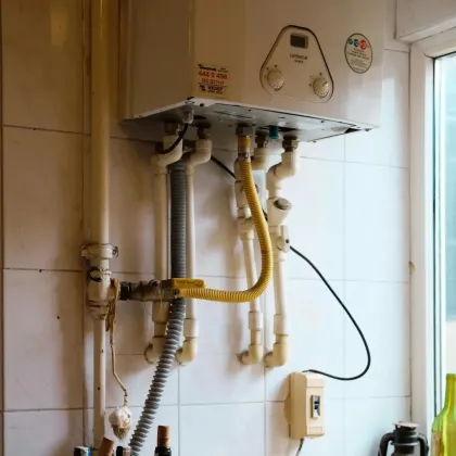 JM Plumbing Inc | a white water heater is mounted to a white tiled wall