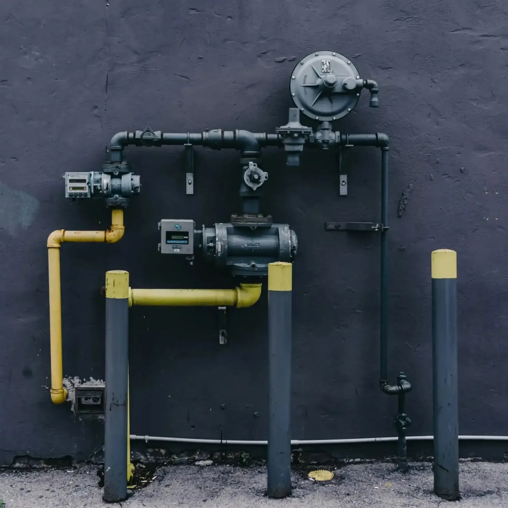 JM Plumbing Inc | A black wall with a bunch of pipes attached to it