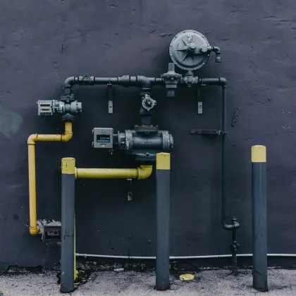 A black wall with a bunch of pipes attached to it