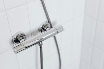 A close up of a shower head in a bathroom.