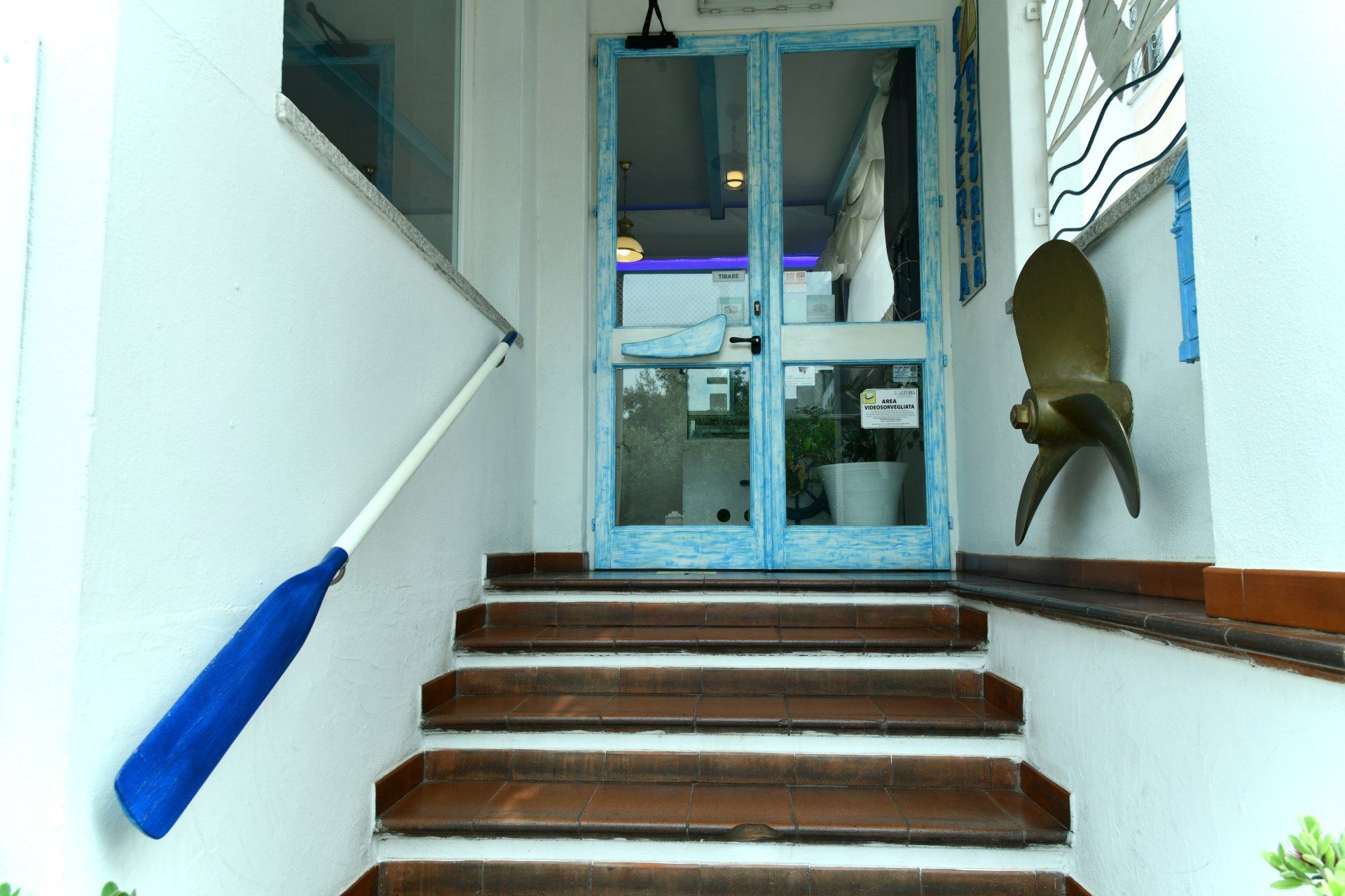 Una rampa di scale che porta ad una porta con una ringhiera blu