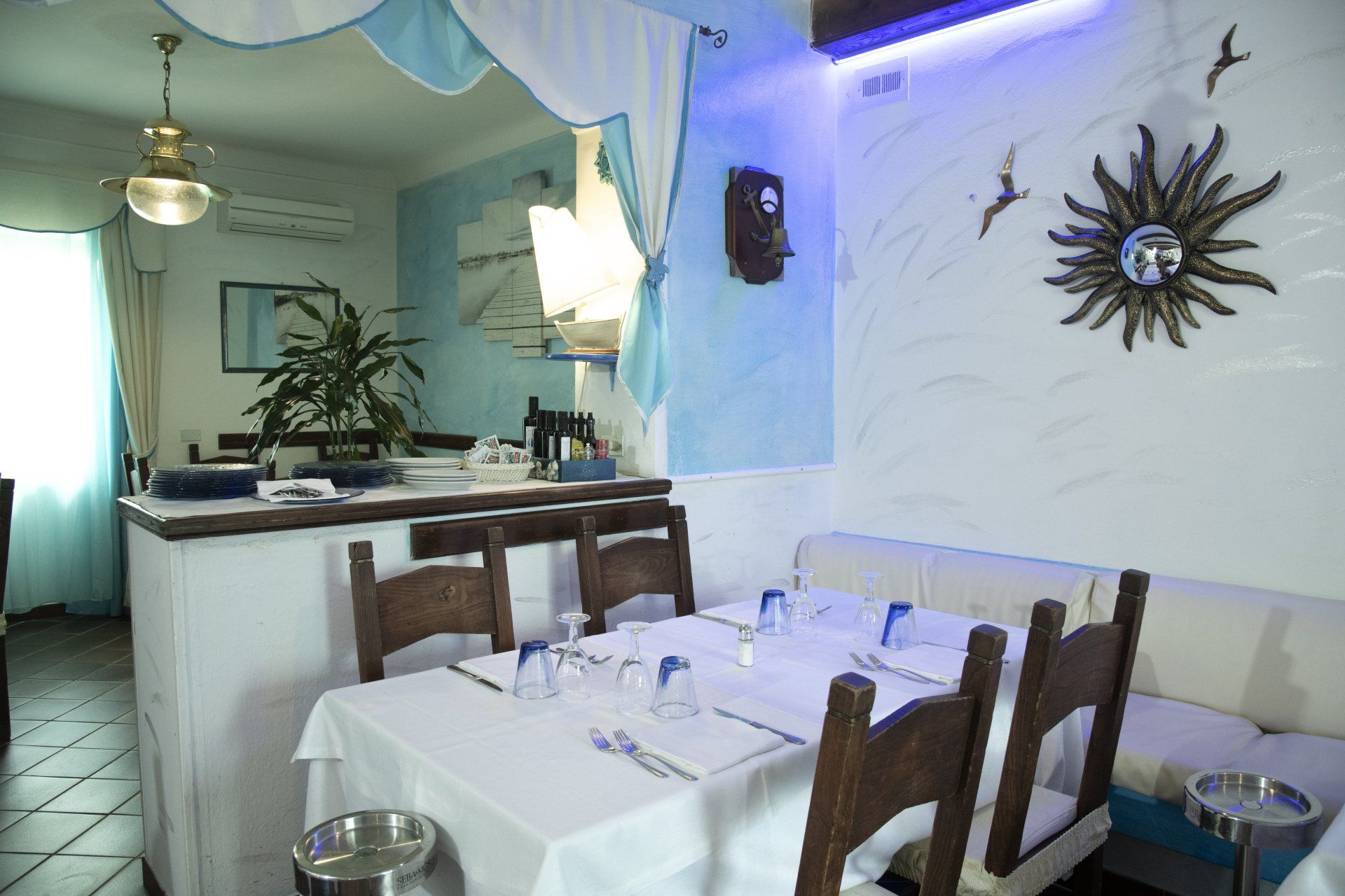 Un ristorante con tavoli e sedie e un sole sul muro