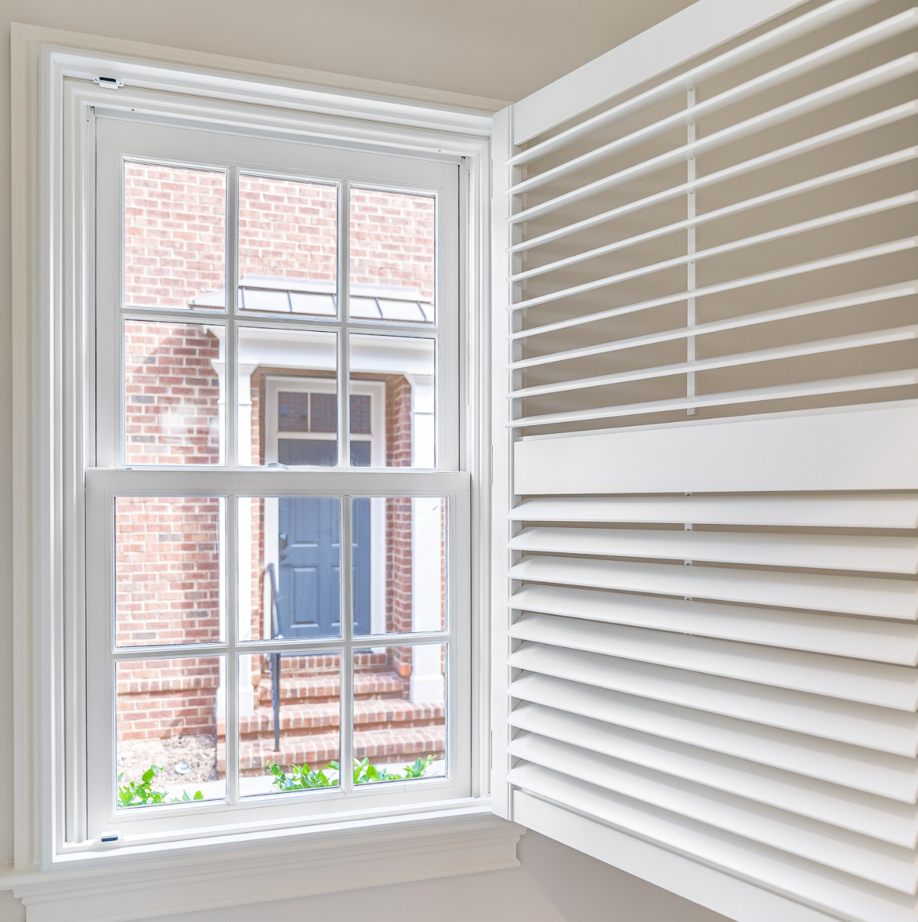 An open shutter on a window with a divider rail