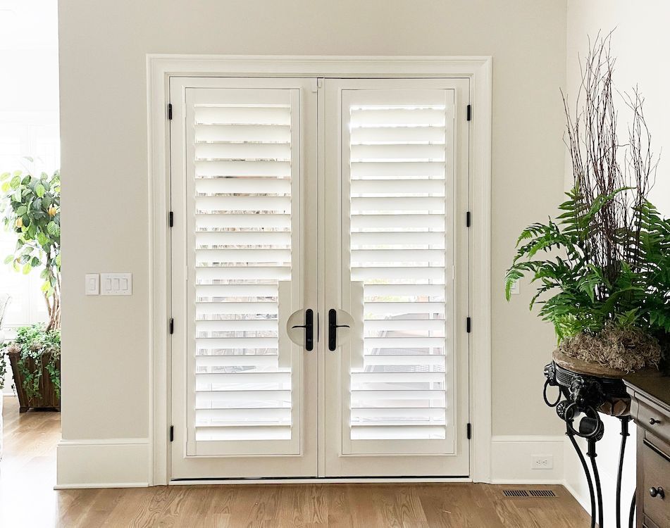 Two french doors covered in hidden tilt shutters with no center tilt rod
