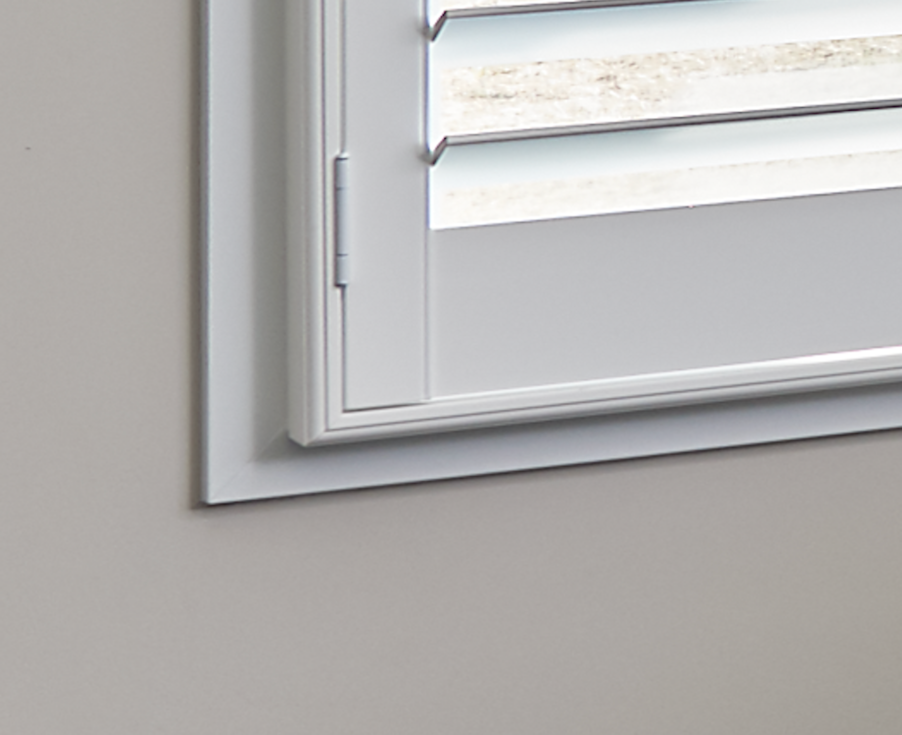 A close up of a plantation shutter corner showing an outside mount shutter on farmwood trim.