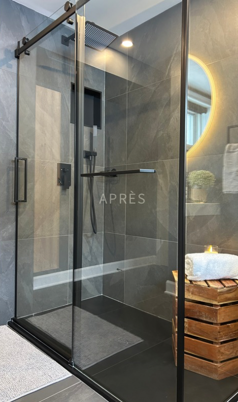 Cabine de douche moderne en verre avec cadre noir dans une salle de bain élégante