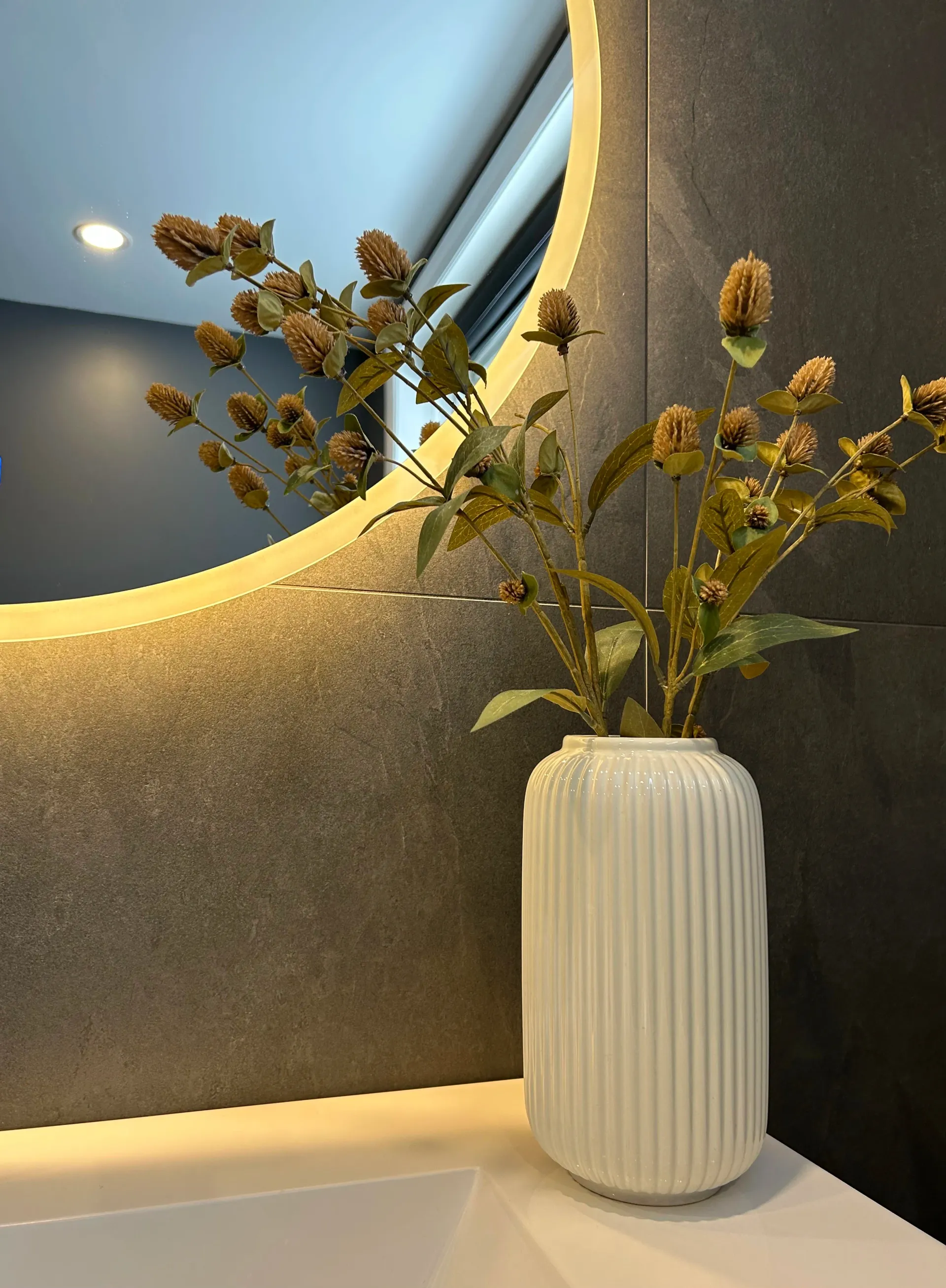 Des fleurs séchées dans un vase blanc