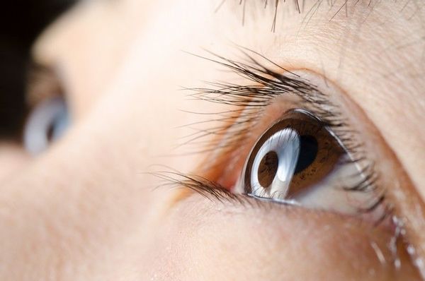 A close up of a woman 's eye with long eyelashes.