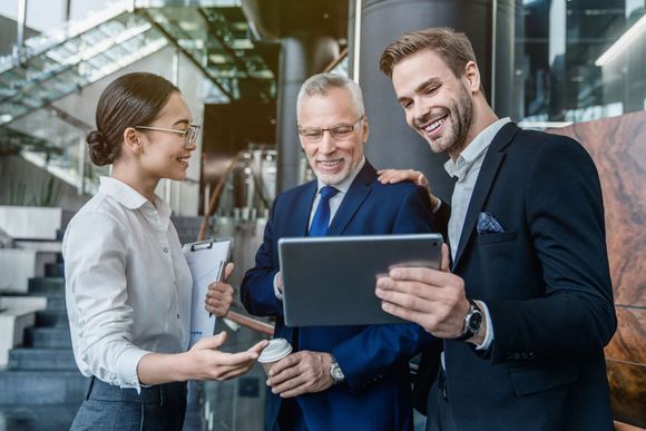 Group Of Coworkers In Suits Working Together On Digital Tablet — Placida, FL — Accounting 4 Profitability LLC