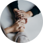 Hands stacked together in a teamwork gesture against a dark background