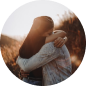Two people embracing at sunset, with warm backlighting and blurred background