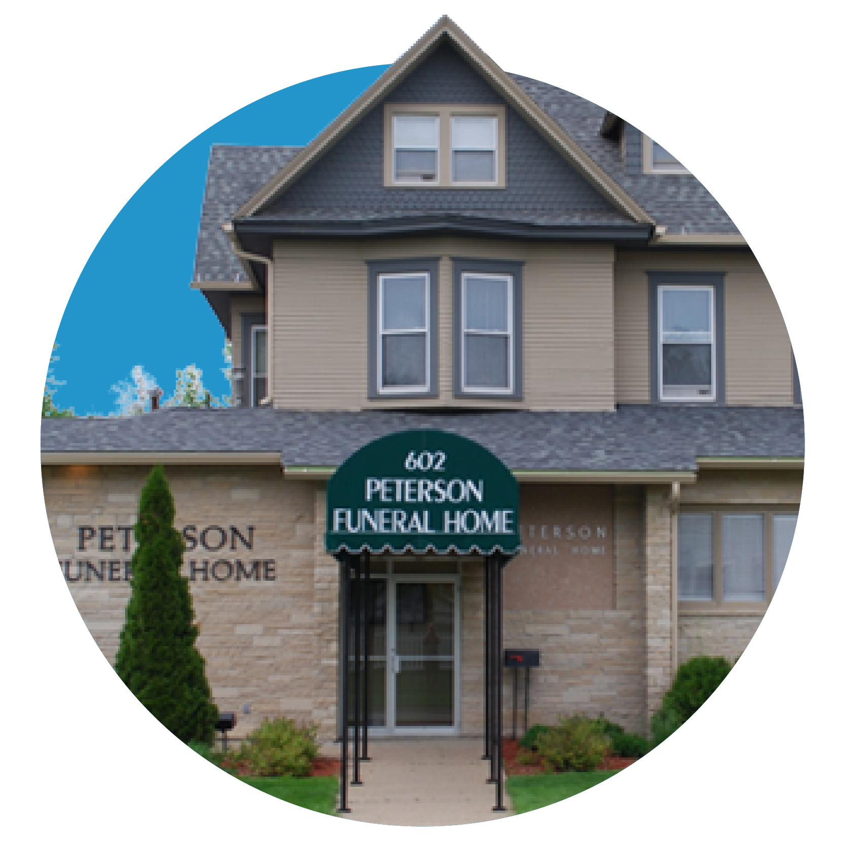 Peterson Funeral Home entrance with green awning on a beige and gray building under blue sky