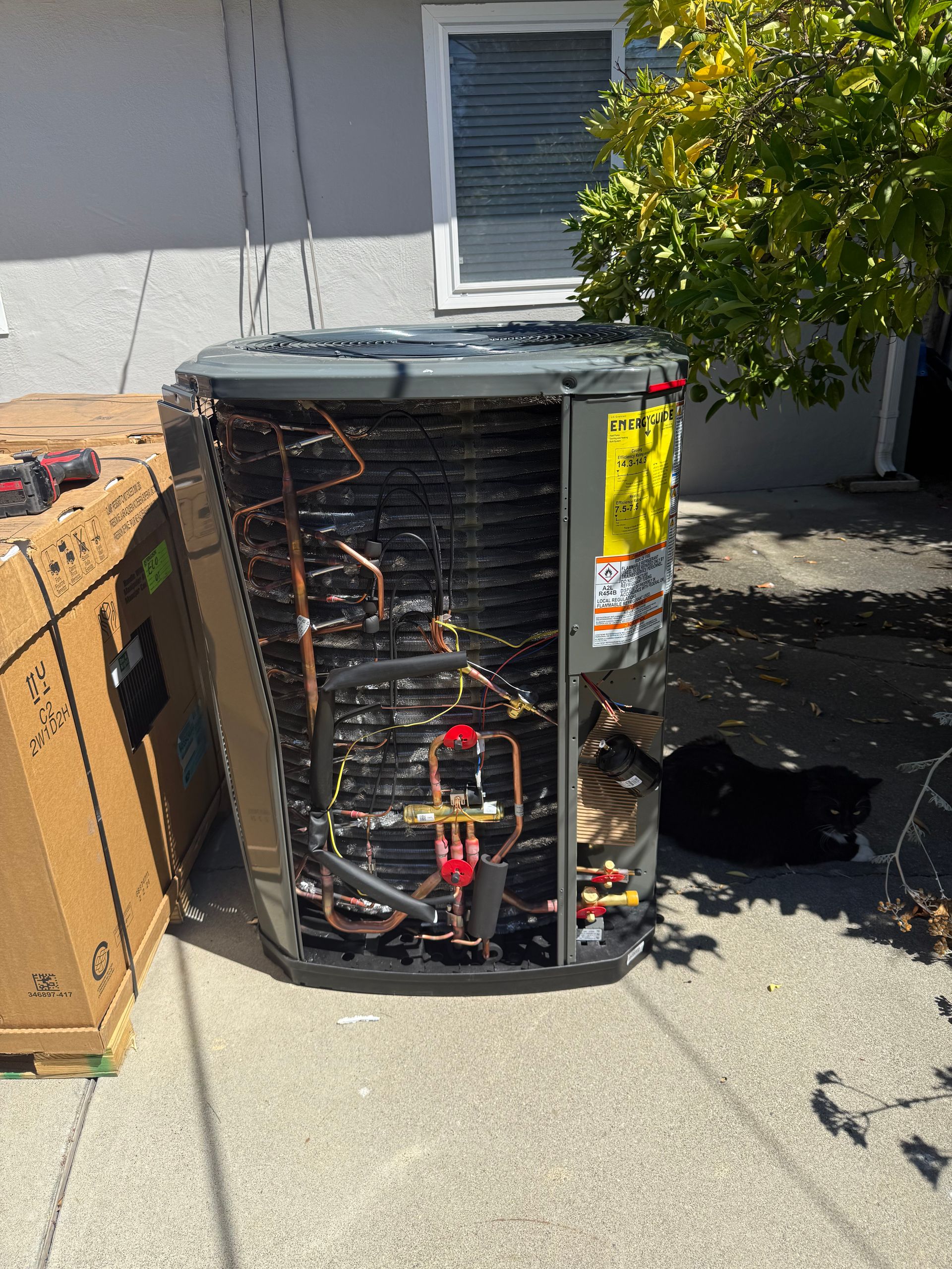 Hand using a torch to solder copper pipes on an air conditioning unit.