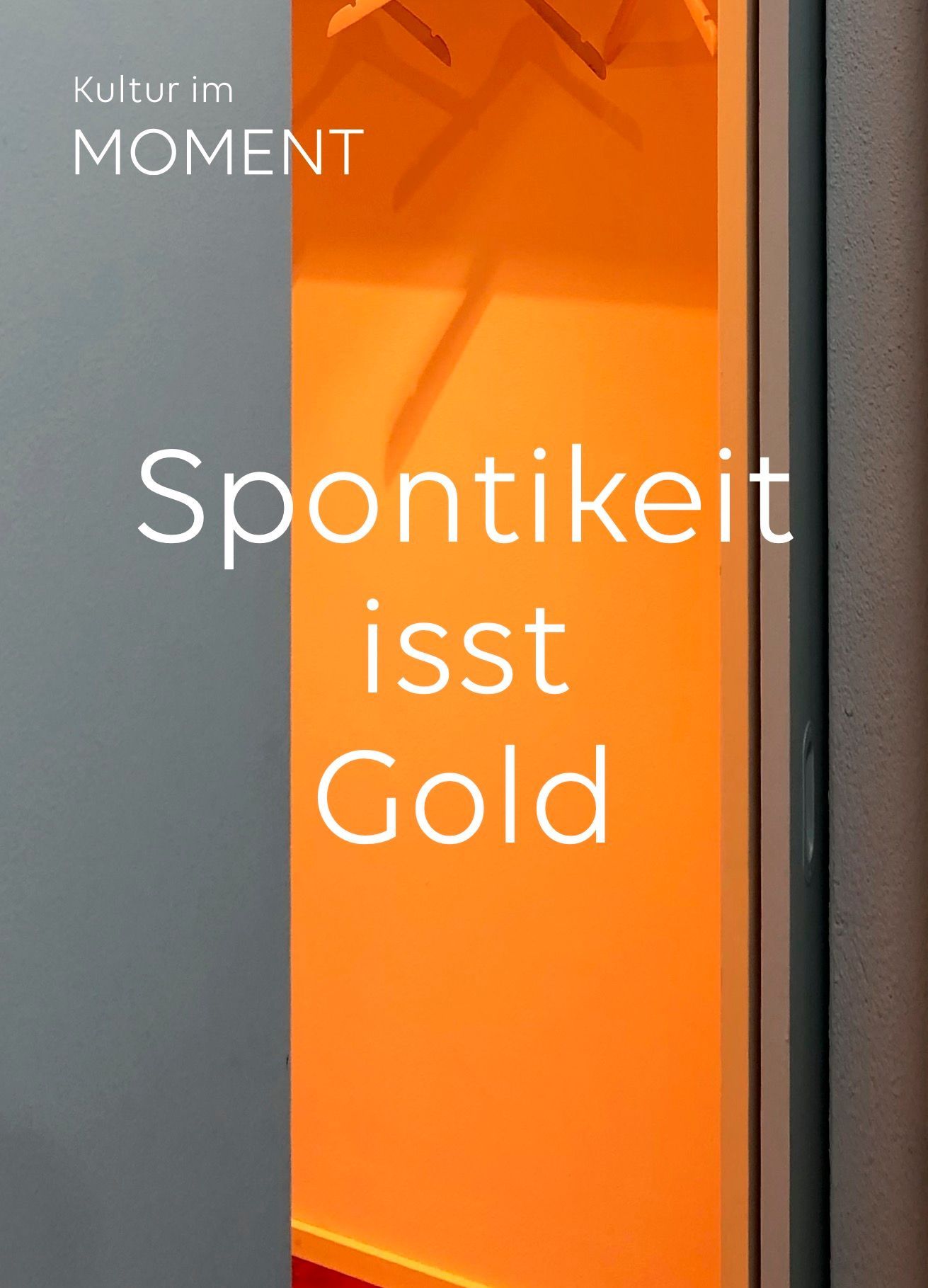 Text „Spontikeit ist Gold“ auf orangefarbenem Hintergrund. Grauer Türrahmen teilweise sichtbar.