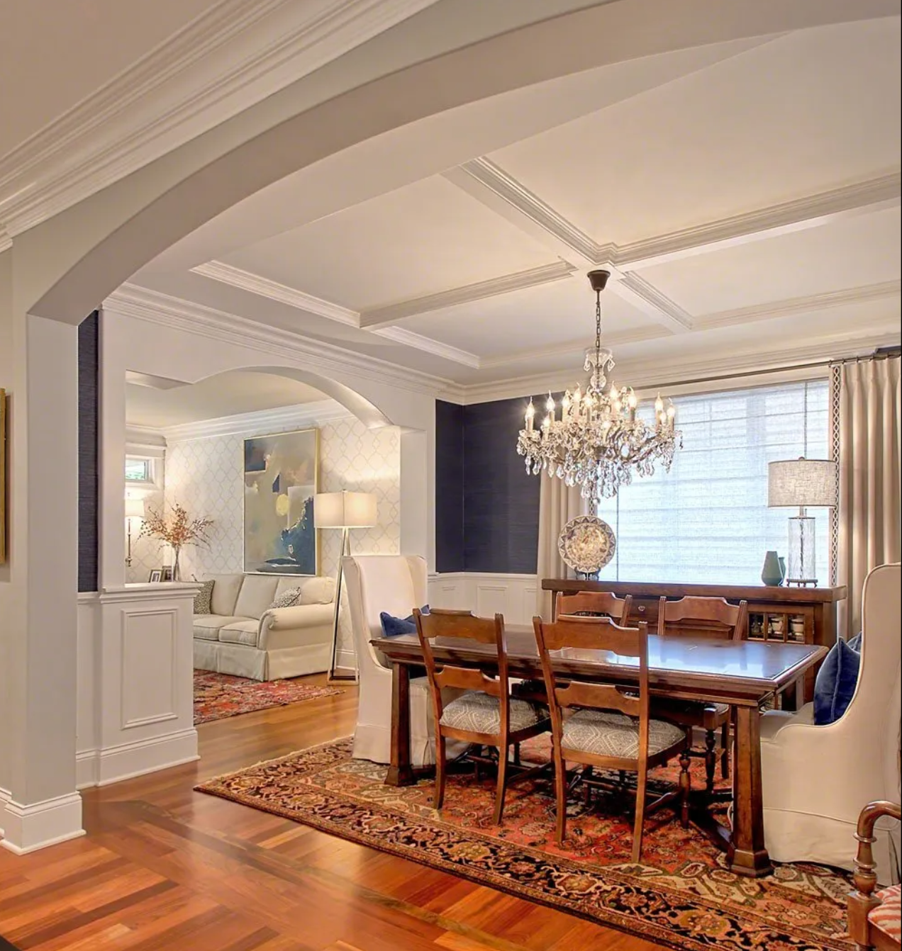 A dining room with a table and chairs and a chandelier