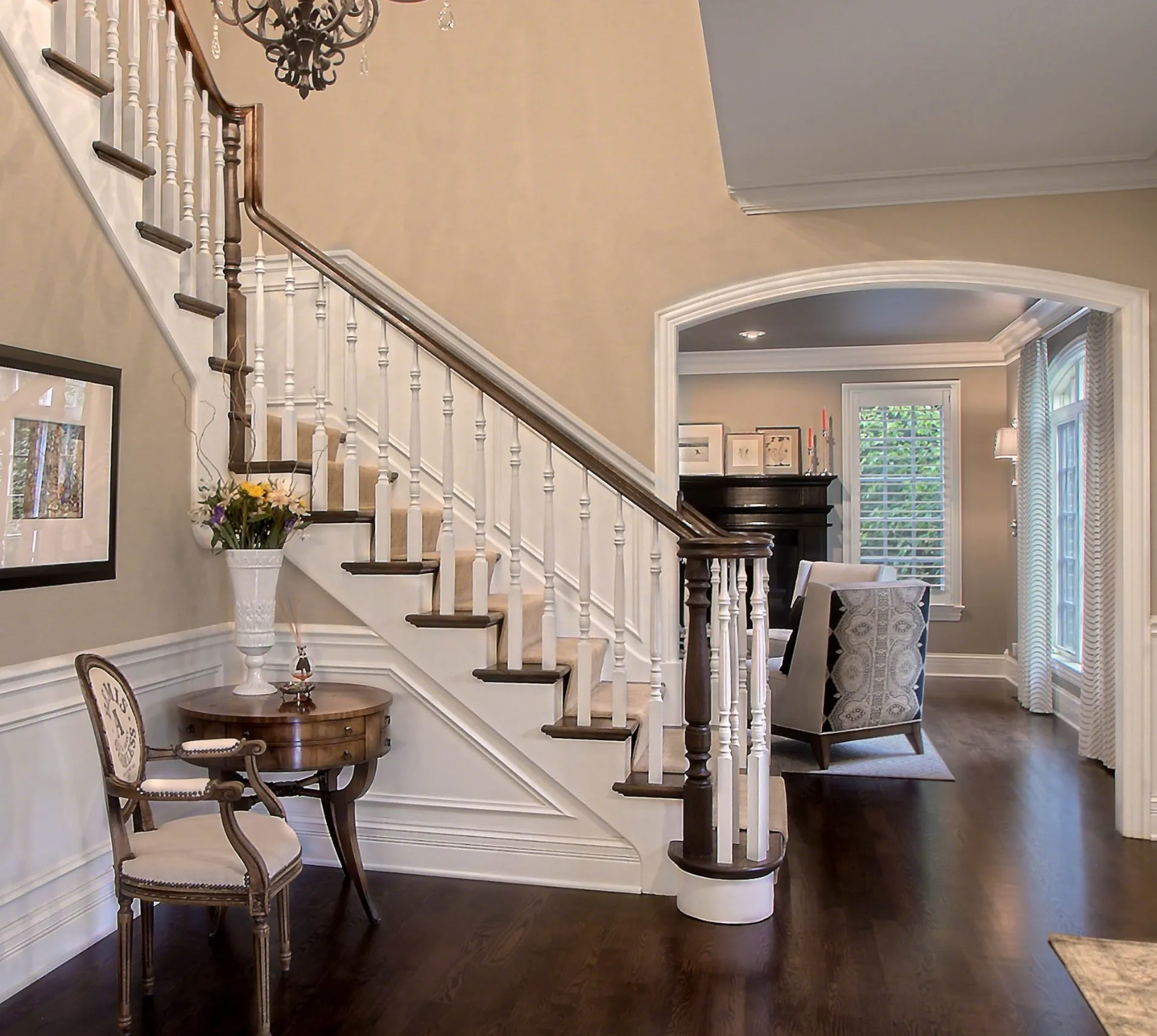A staircase in a living room with a table and chairs