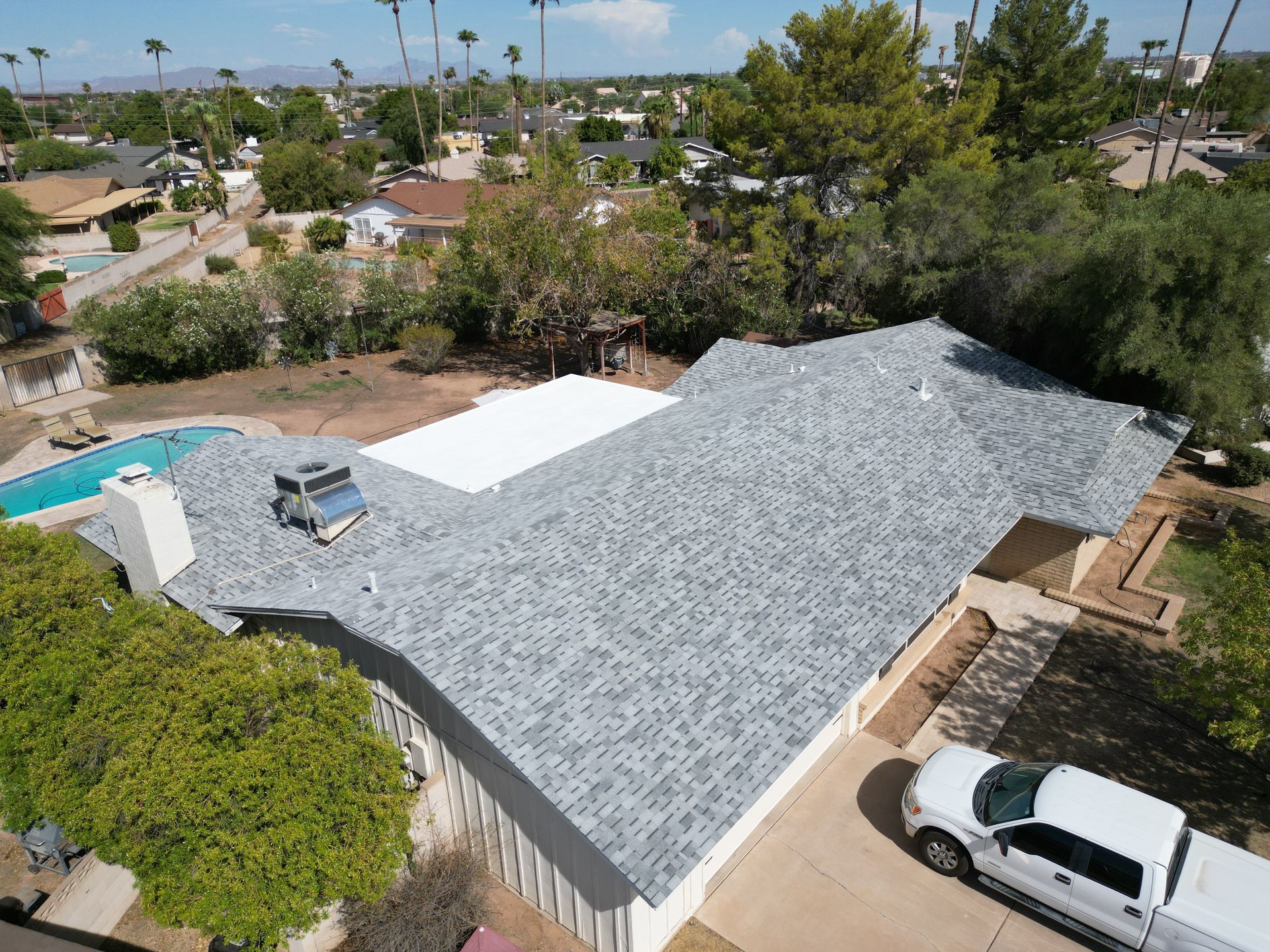 Two gray asphalt shingle roof sections meeting at an angle.