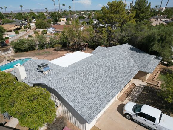 Two gray asphalt shingle roof sections meeting at an angle.