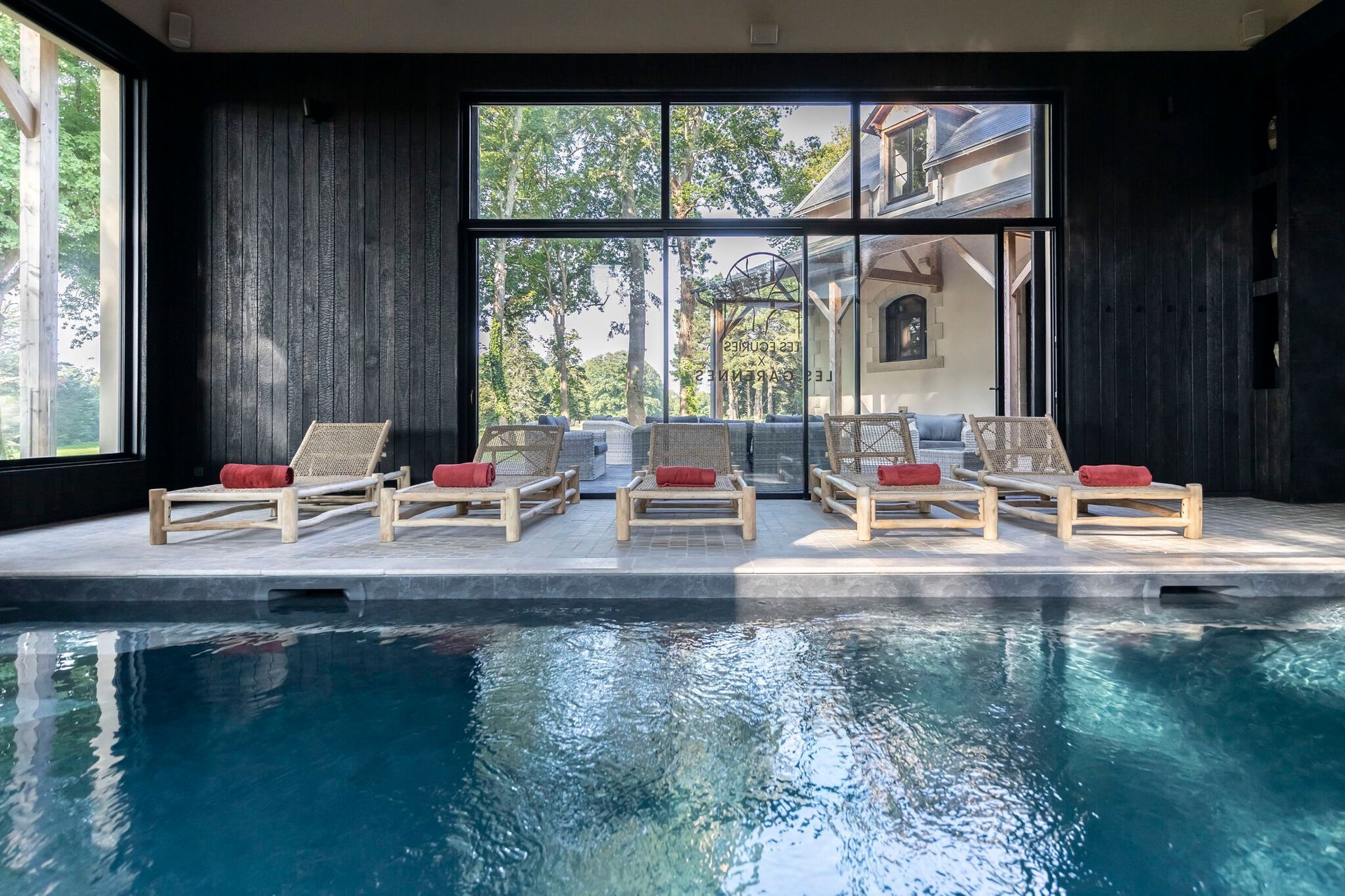 Une grande piscine intérieure avec beaucoup de chaises autour.