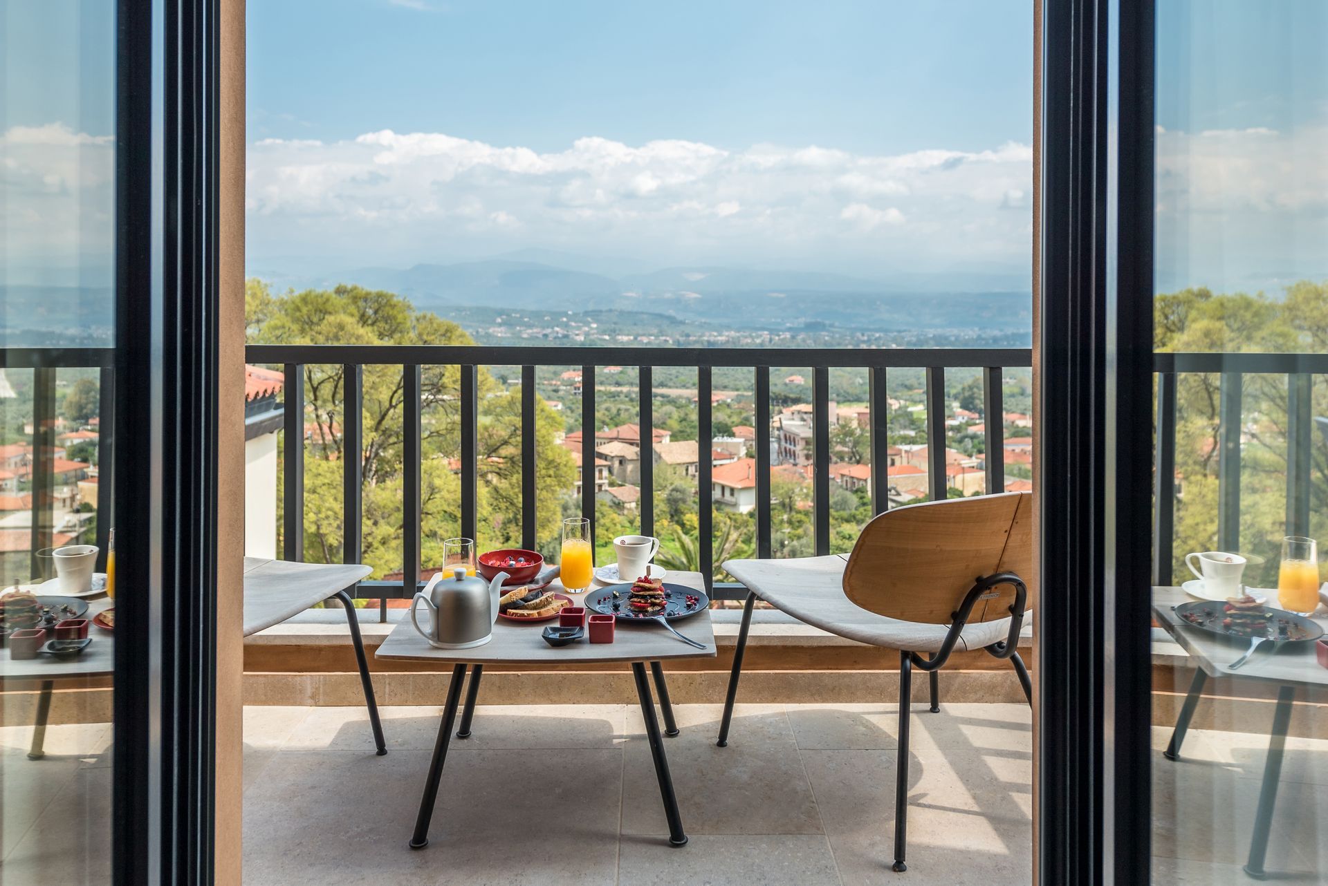 Un balcon avec une table et des chaises et une vue sur une ville.